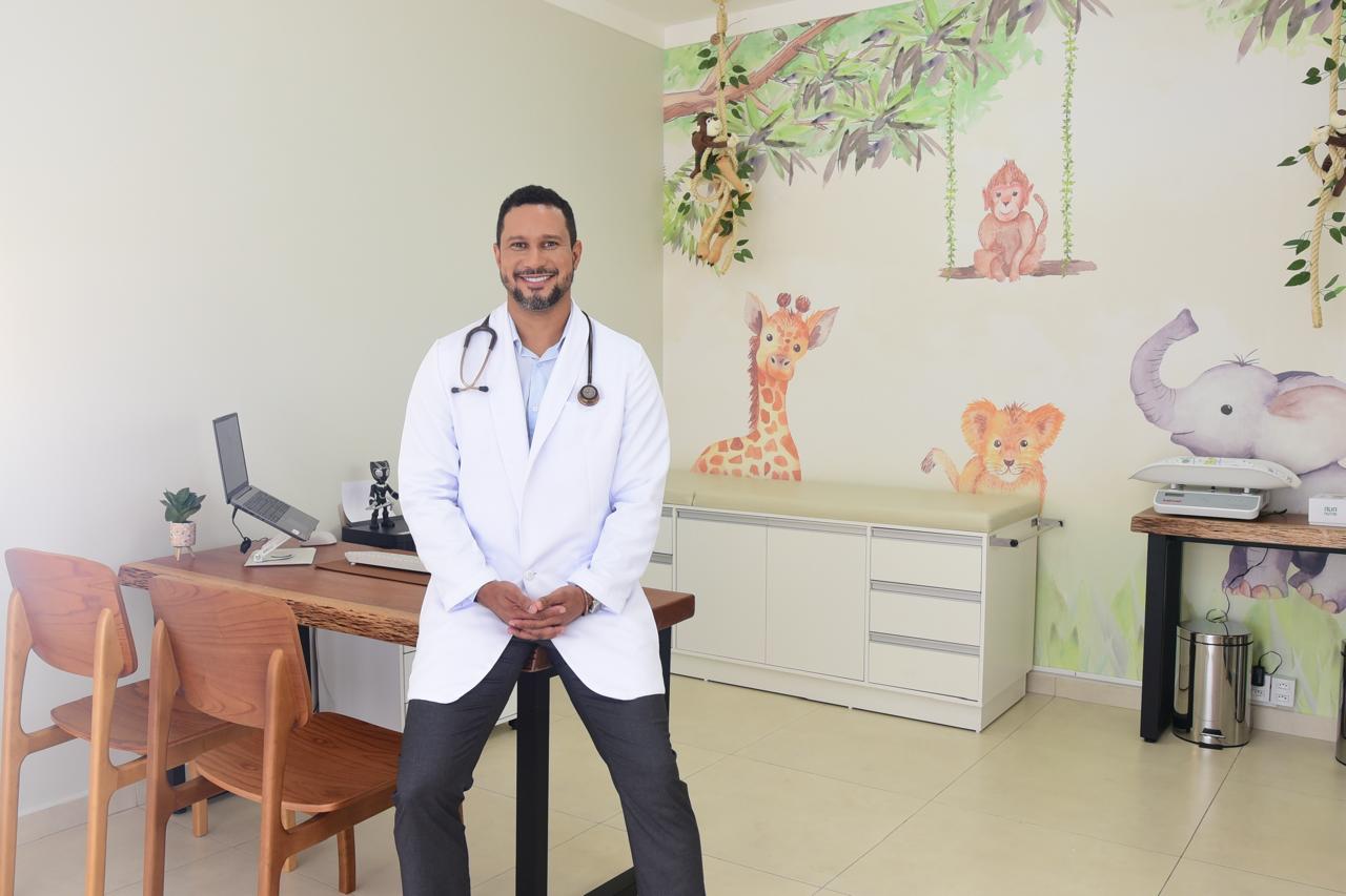 Dr. Pedro Ivo sorrindo no consultório pediátrico